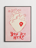 You Are Here minimalist typography poster with a heart, framed on a wall